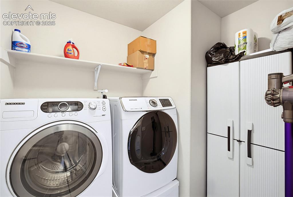 Image 39 of 50: Laundry area featuring wall-mounted shelving and a tall storage cabinet wit