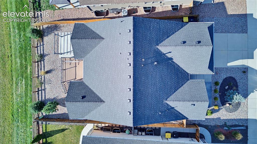 Image 4 of 50: Aerial view featuring a multi-gabled asphalt shingle roof, concrete drivewa