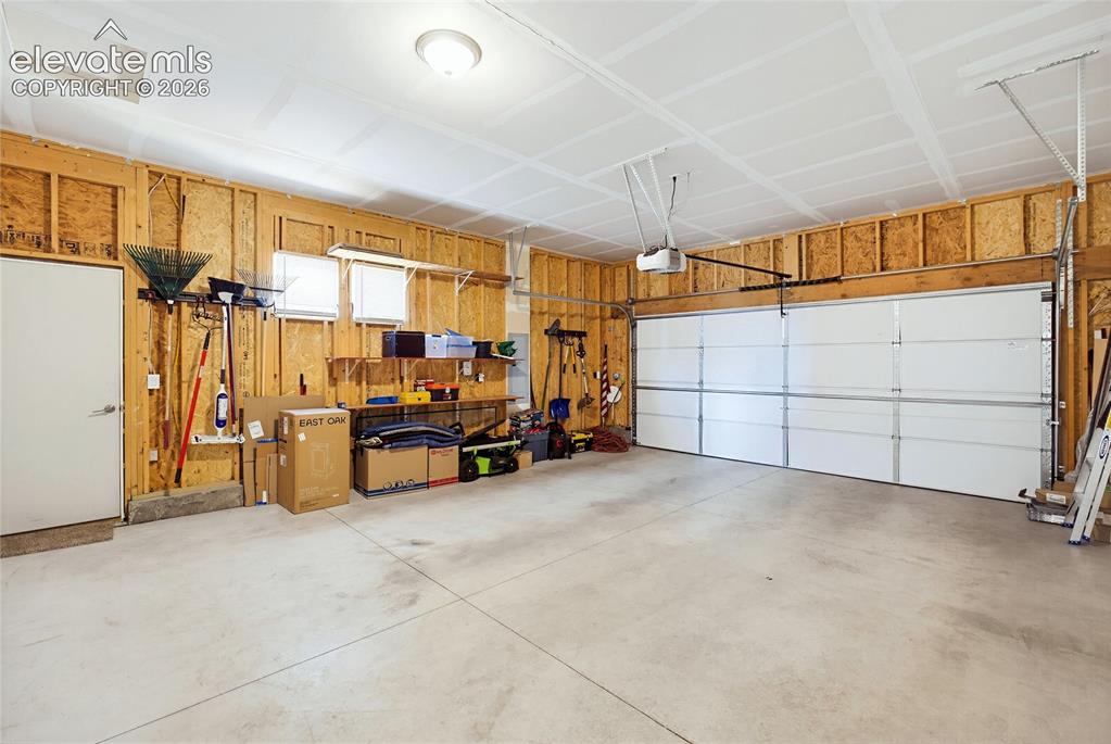 Image 40 of 50: Attached two-car garage featuring a concrete floor, white sectional door, e
