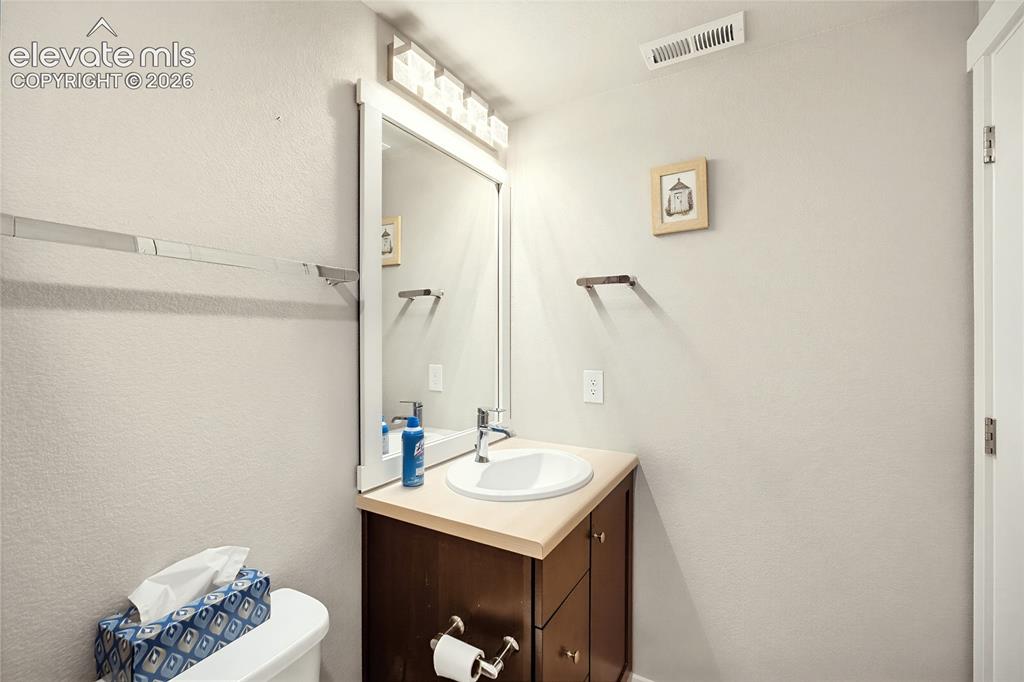 Image 49 of 50: Dark wood vanity featuring a light-toned countertop, integrated white oval 