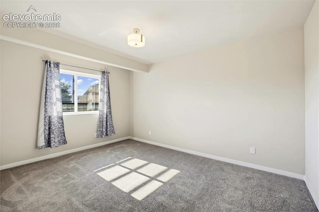 Image 50 of 50: Neutral wall paint, plush carpeting, single-pane window, and a semi-flush m
