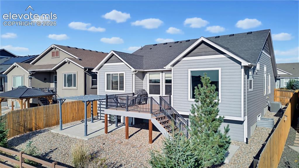 Image 6 of 50: Rear exterior featuring horizontal lap siding, elevated deck with black met