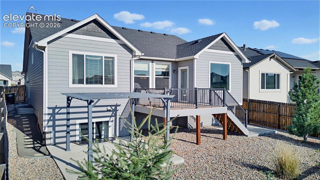 Image 7 of 50: Rear exterior featuring horizontal lap siding, a composite deck with metal