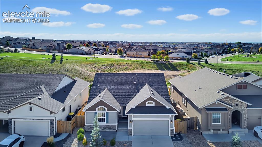 Image 8 of 50: Single-family residence featuring a composite shingle roof, stone veneer ac