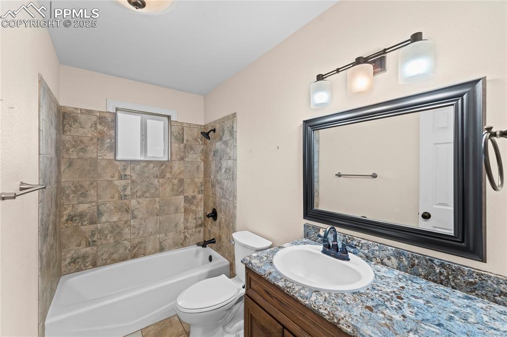 Image 12 of 34: First floor Bathroom featuring vanity and washtub / shower combination