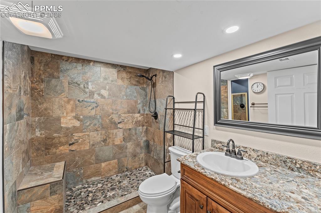 Image 21 of 34: Basement Bathroom with a tile shower and vanity