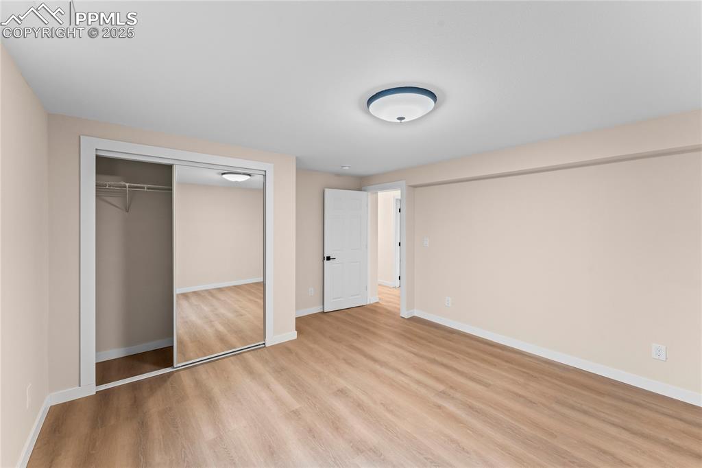 Image 22 of 34: Unfurnished bedroom with light wood-style floors and a closet