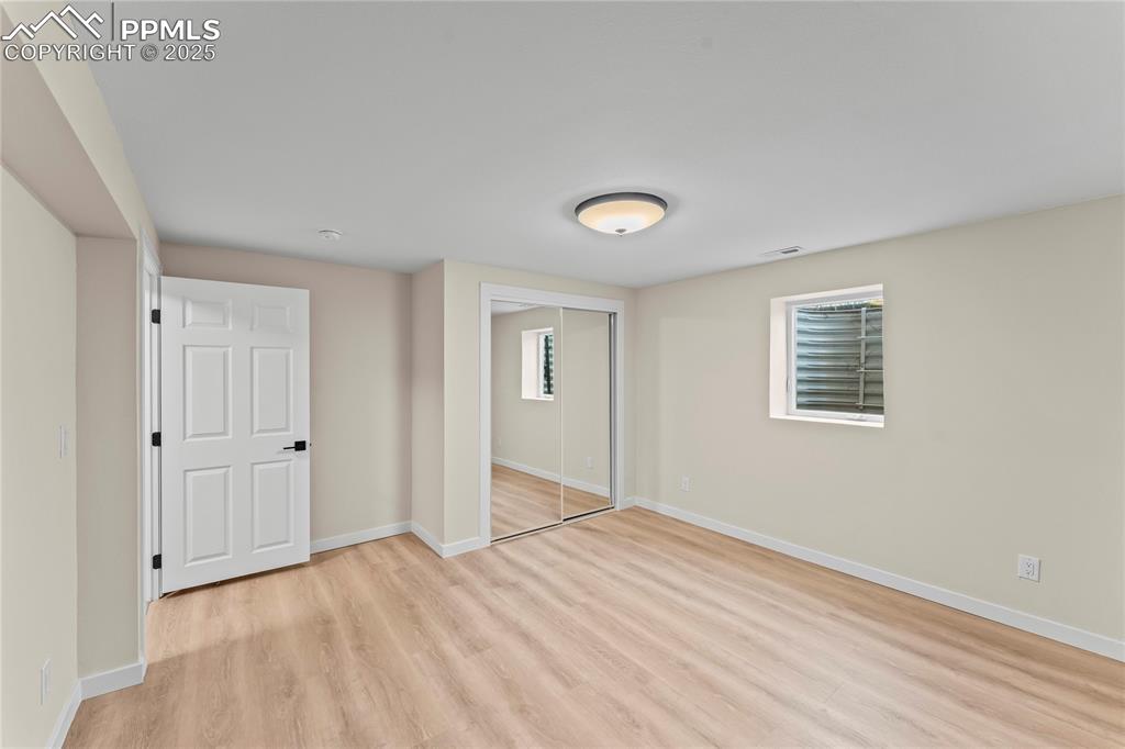 Image 23 of 34: Unfurnished bedroom featuring light wood-style floors, a closet, and multip