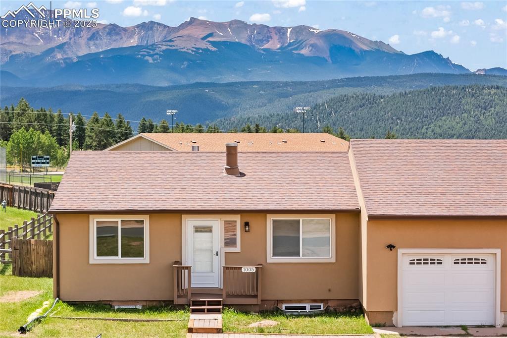 Image 29 of 34: View of front of house featuring a mountain view, roof with shingles, stucc