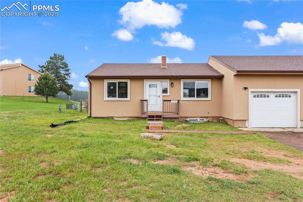 Image 3 of 34: View of front of house featuring a garage, a front lawn, stucco siding, and