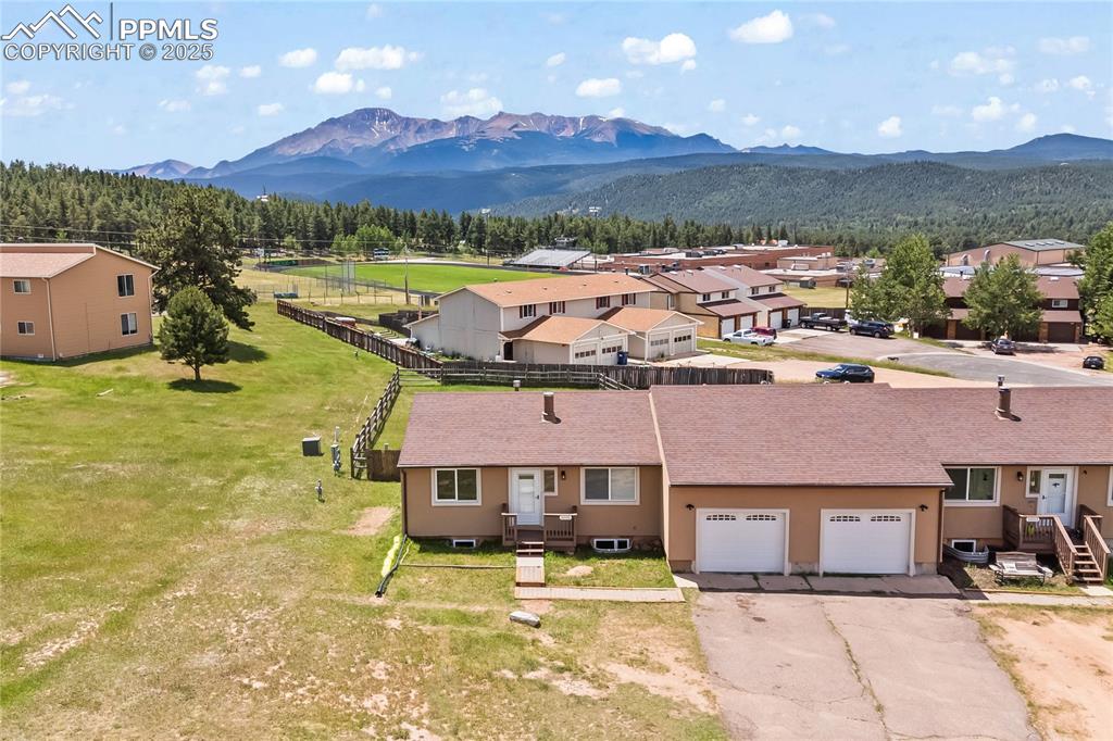 Image 30 of 34: Aerial view of residential area featuring a mountainous background