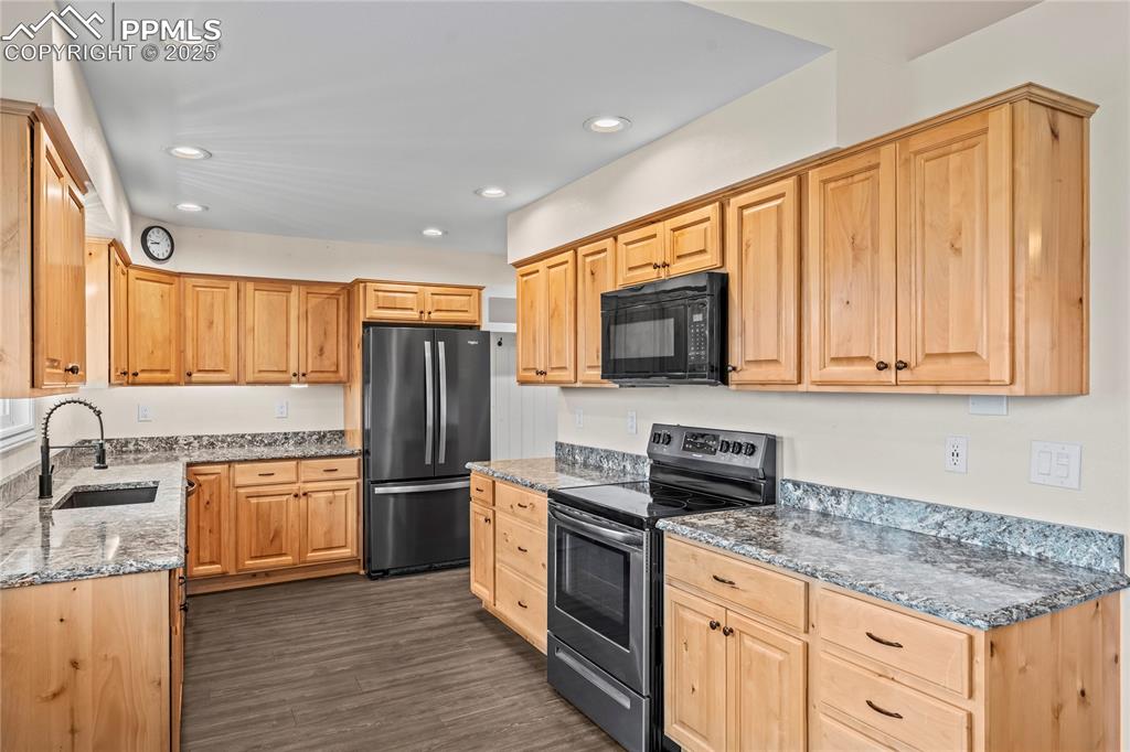 Image 8 of 34: Kitchen featuring stainless steel appliances, stone counters, light brown c