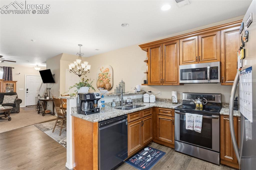 Image 10 of 26: Kitchen featuring wood finish cabinetry, stainless steel appliances, a peni