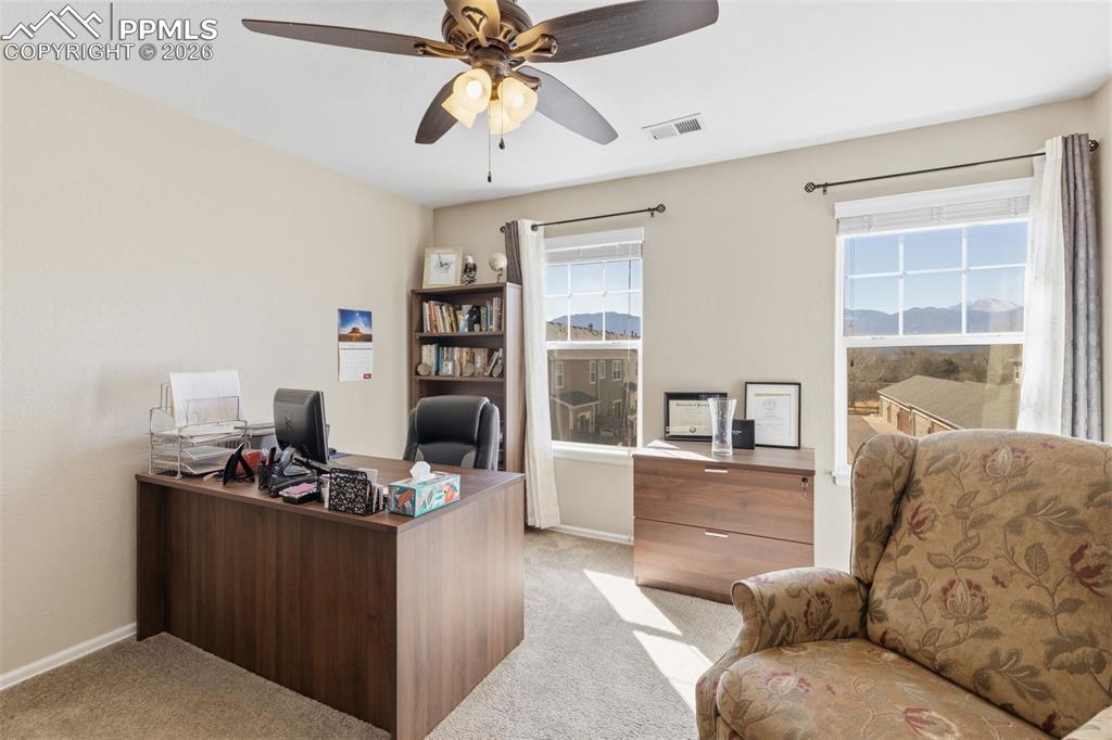 Image 14 of 26: Home office with light colored carpet and a ceiling fan