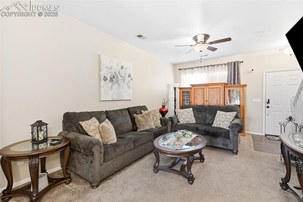 Image 5 of 26: Living room with light colored carpet and ceiling fan