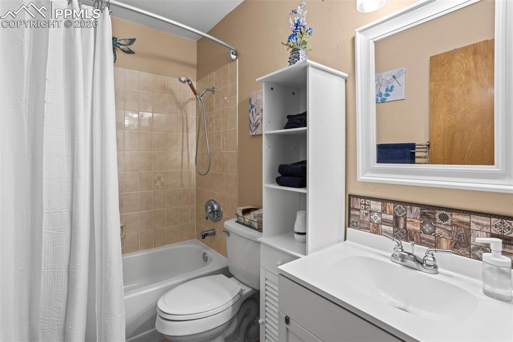 Image 15 of 26: Main level bathroom with tub/shower - storage cabinet stays with home