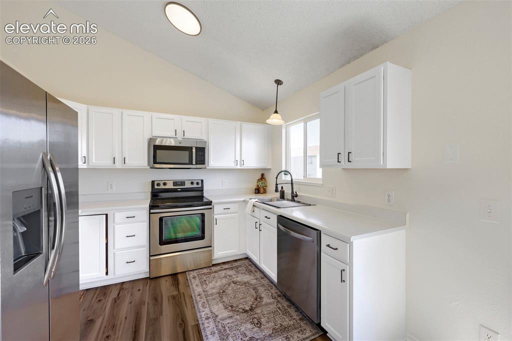 Image 10 of 35: Kitchen featuring white cabinetry, stainless steel appliances, white counte
