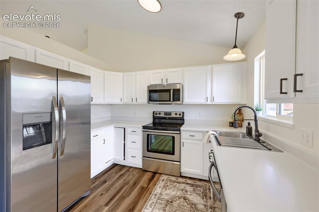 Image 11 of 35: Kitchen featuring white cabinetry, stainless steel appliances, white counte