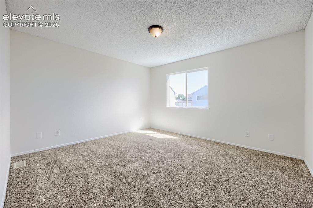 Image 12 of 35: White walls with neutral carpeting