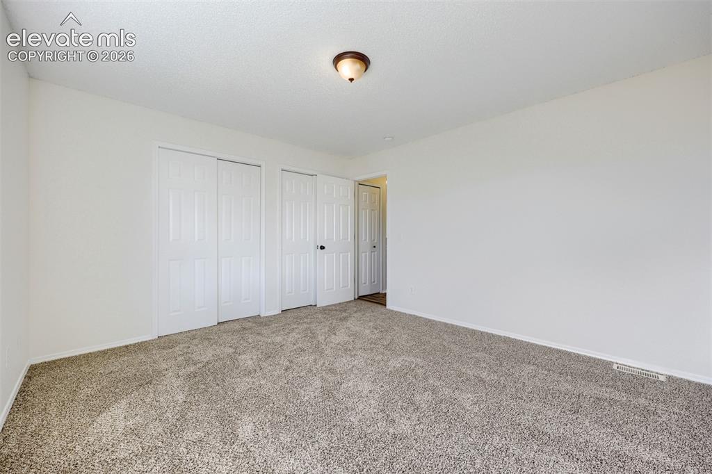 Image 14 of 35: Wall-to-wall carpeting and white walls
