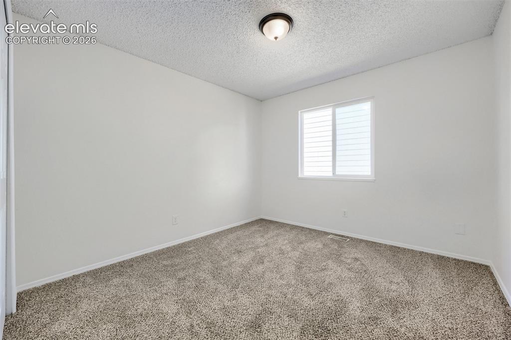 Image 16 of 35: White painted walls with wall-to-wall carpeting