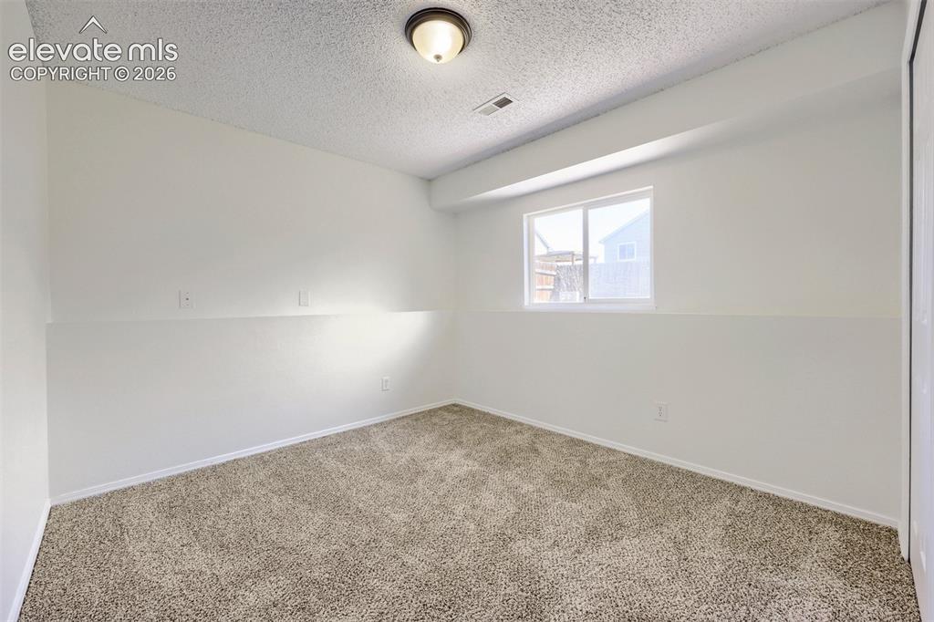 Image 22 of 35: Recessed window with white trim, neutral carpeting, flush-mount ceiling lig