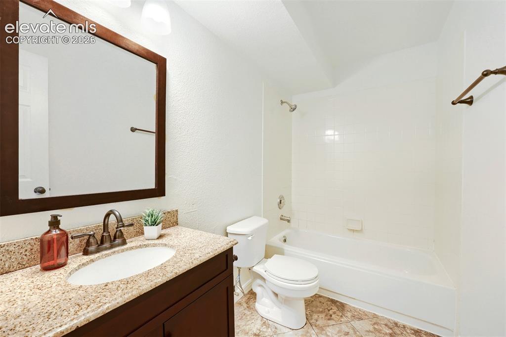 Image 27 of 35: Vanity with integrated sink, stone-finish countertop, and dark-finish cabin