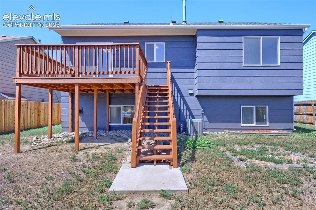 Image 30 of 35: Elevated wood deck with baluster railing, wood staircase, and horizontal si