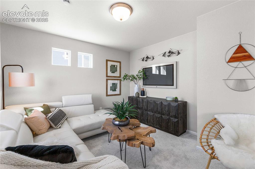Image 10 of 31: Modern living room featuring a light gray carpeted floor, sectional seating