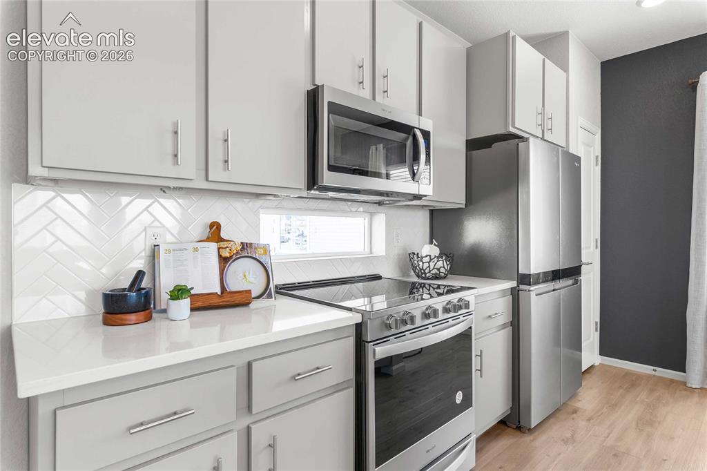 Image 13 of 31: Kitchen featuring light-toned cabinetry, stainless steel appliances, white
