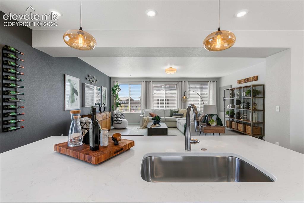Image 15 of 31: Kitchen island with a stainless steel undermount sink, gooseneck faucet, an
