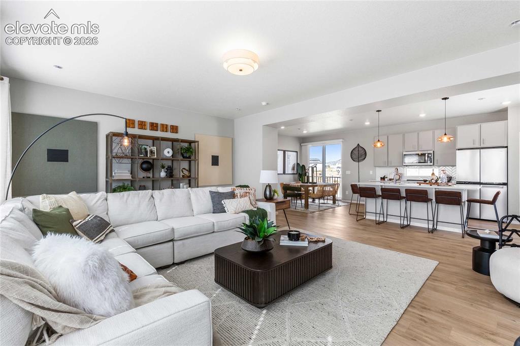 Image 16 of 31: Open-concept living space featuring wood-finish flooring, recessed lighting