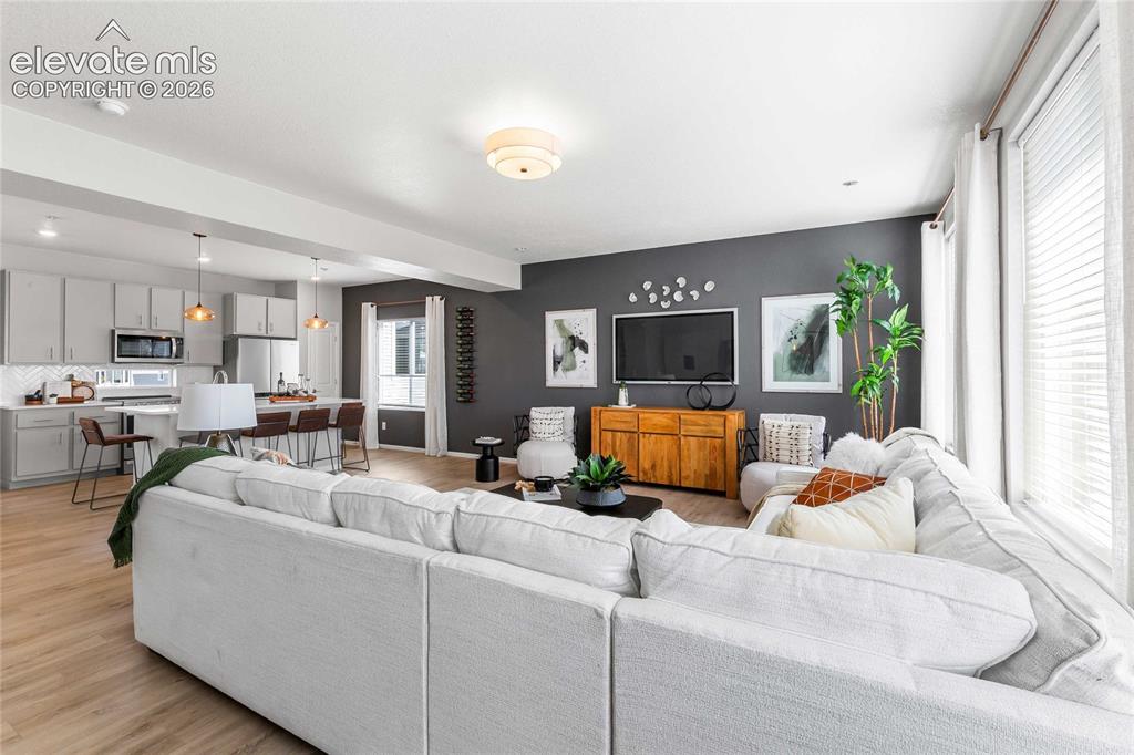 Image 18 of 31: Open-concept living area featuring wood-finish flooring, recessed lighting,