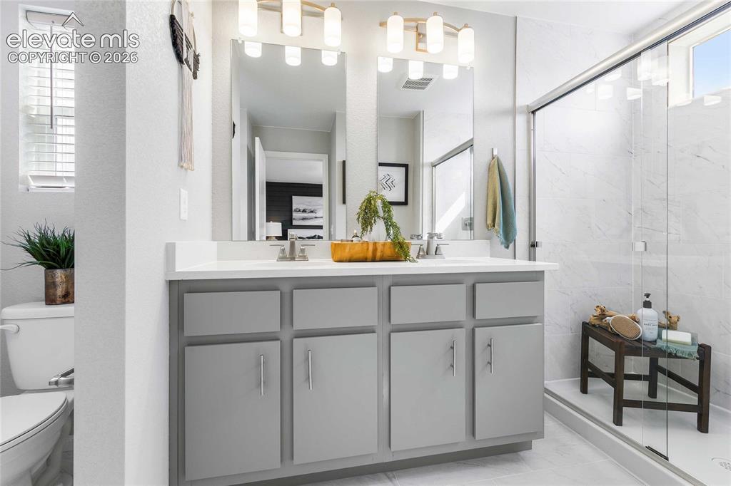 Image 22 of 31: Dual vanity with gray cabinetry, white countertop, and brushed nickel hardw