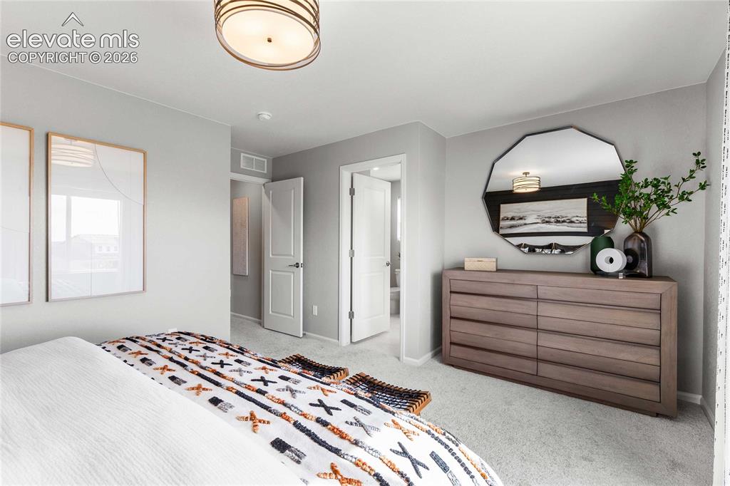 Image 23 of 31: Spacious primary bedroom featuring neutral wall finishes, engineered wood-f