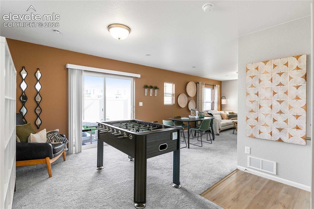 Image 6 of 31: Sliding glass door, light wood-finish flooring, recessed lighting, neutral 