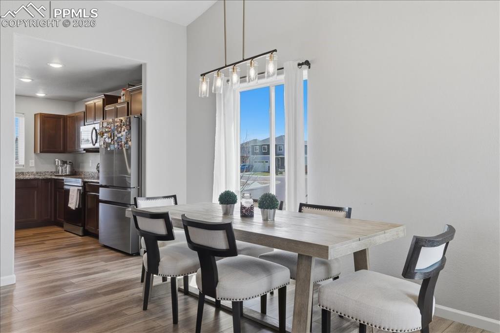 Image 13 of 47: The dining area features a modern linear chandelier and a large window prov