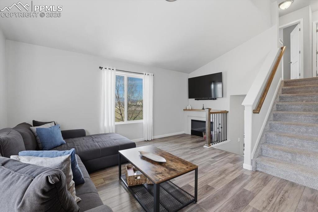 Image 16 of 47: Living room featuring vaulted ceilings, light-colored walls, large windows,