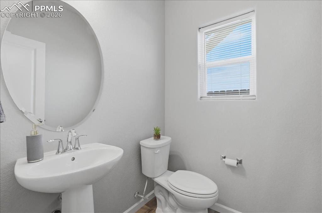 Image 18 of 47: Bathroom featuring a pedestal sink with chrome fixtures, a large oval mirro