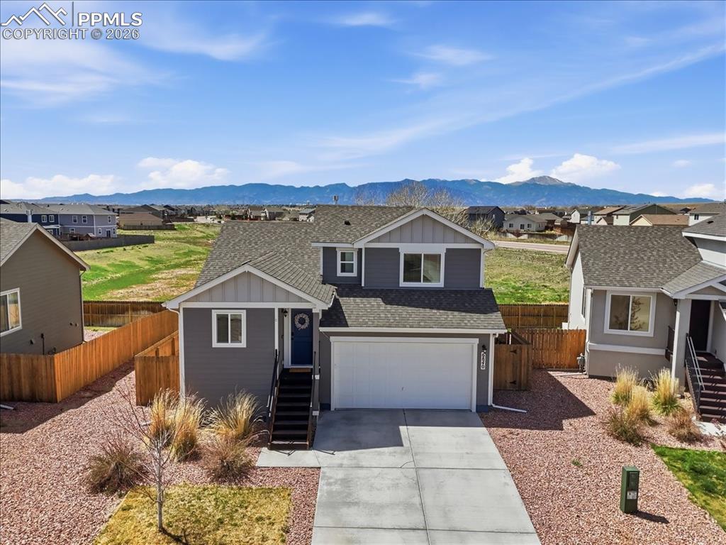 Image 2 of 47: The property features a dark gray exterior with white trim, a two-car garag