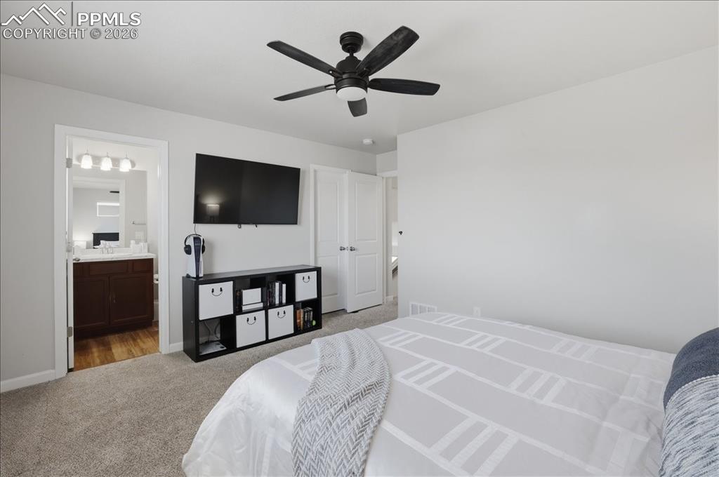 Image 22 of 47: Bedroom featuring light grey walls, carpeted flooring, and a ceiling fan wi