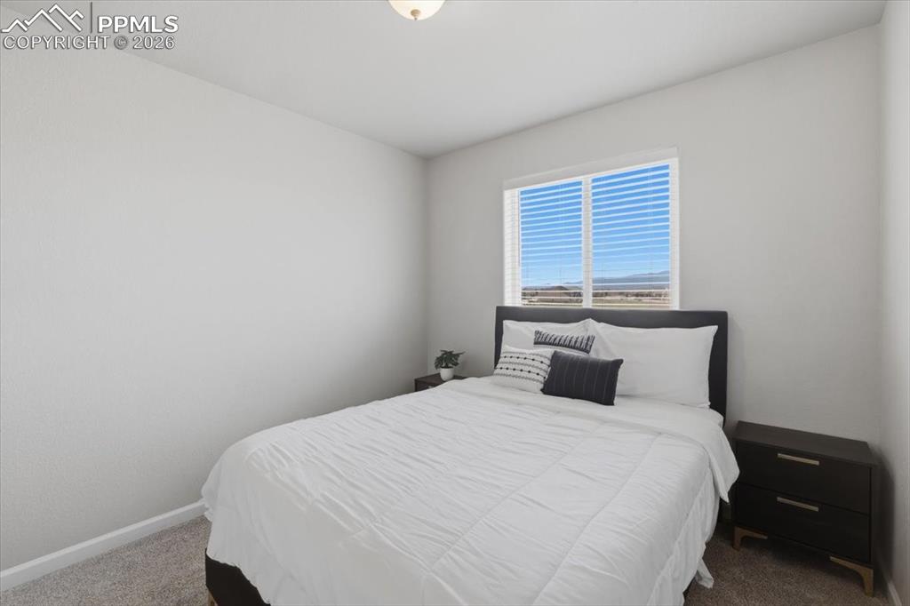 Image 25 of 47: This room features light gray walls, a window with horizontal blinds, and c