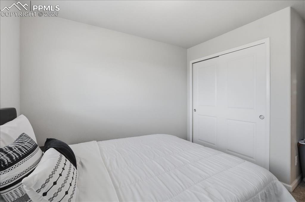 Image 26 of 47: This room features light-colored walls and a closet with white bi-fold door