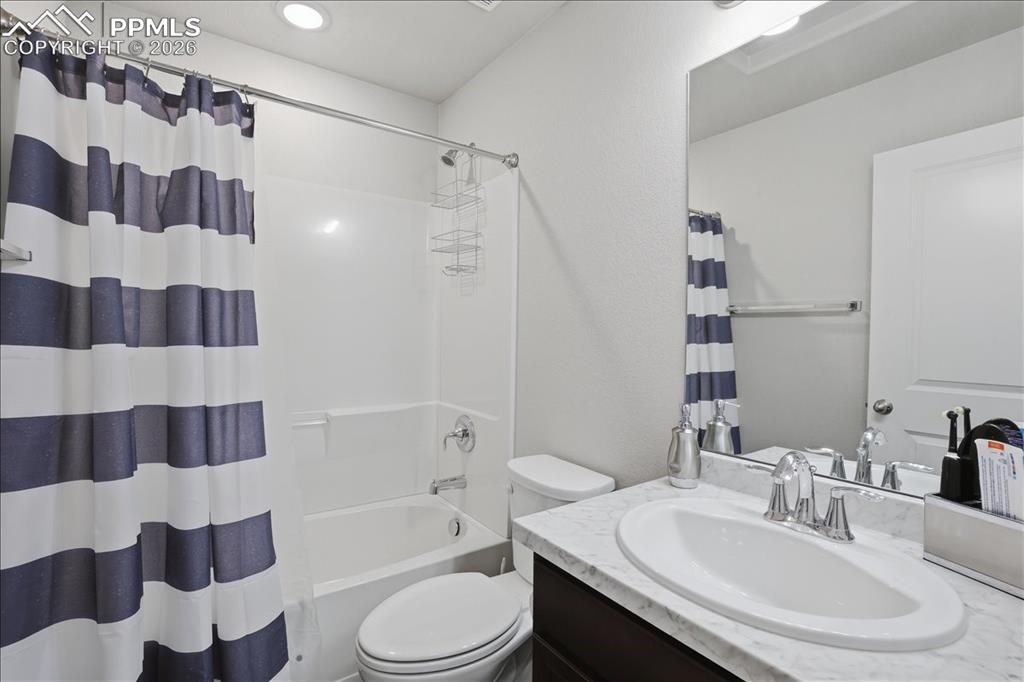 Image 27 of 47: This bathroom features a white bathtub with a shower, a white toilet, and a