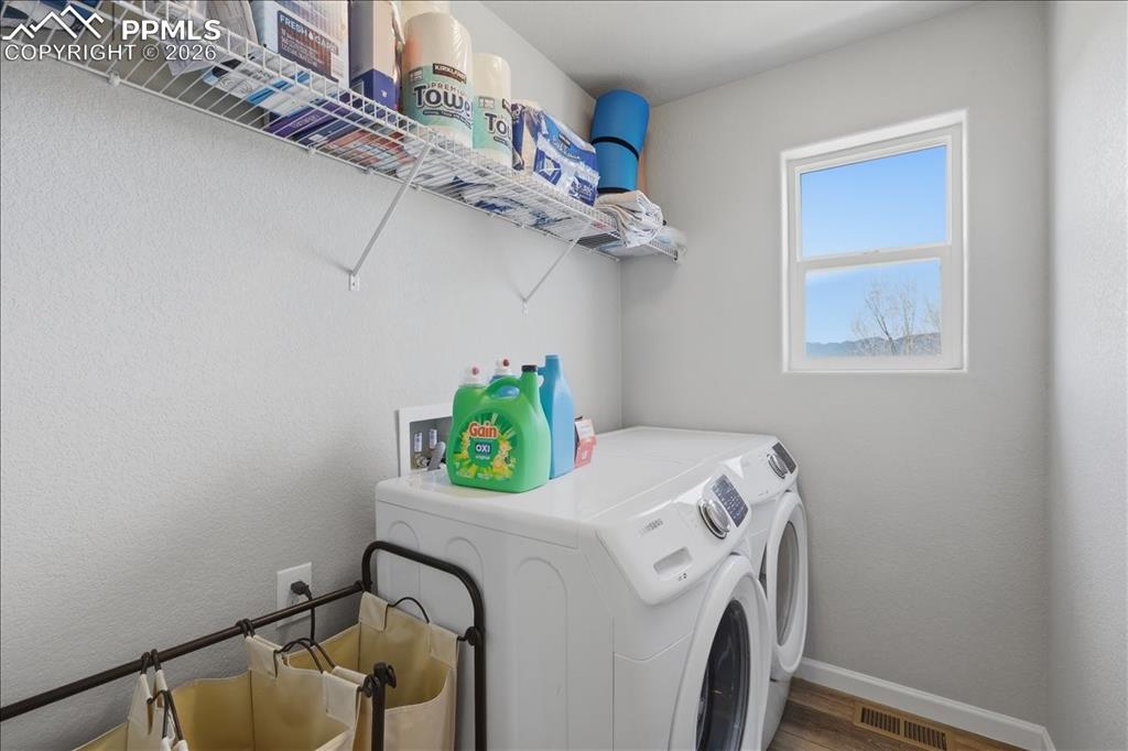 Image 30 of 47: The laundry room features convenient shelving for storage, a window providi