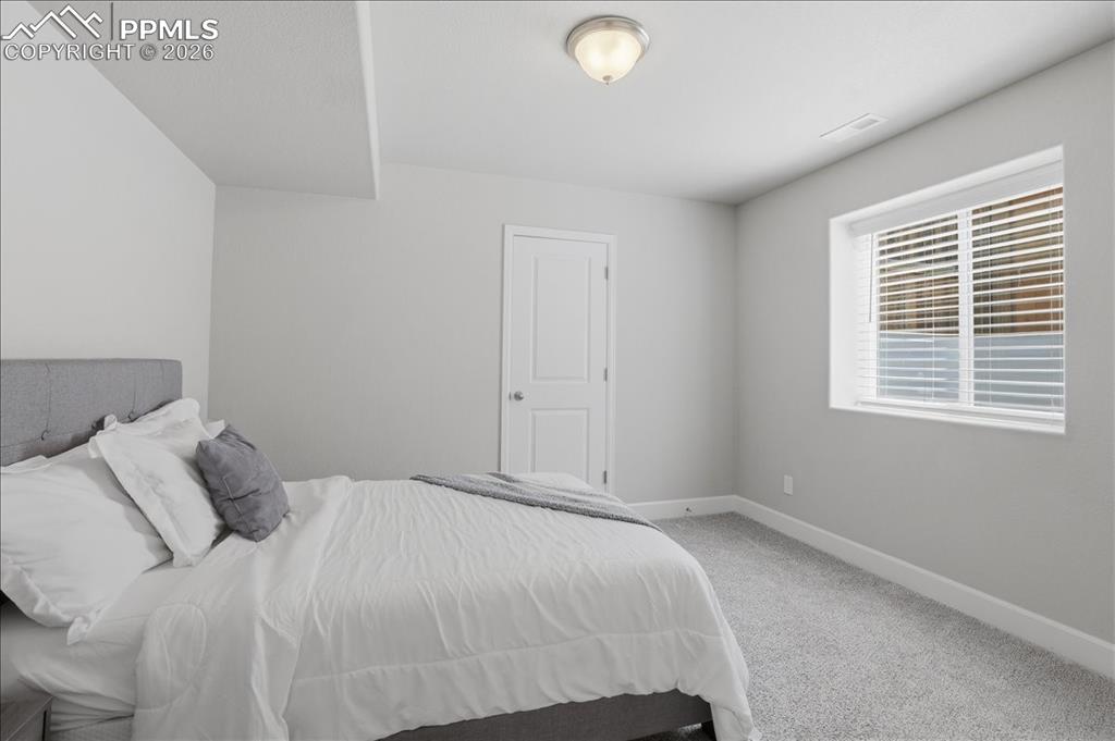 Image 33 of 47: The room features light gray walls, a window with blinds, and light gray ca