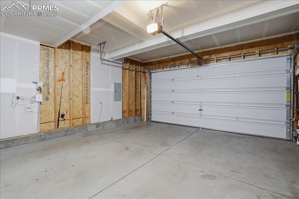 Image 37 of 47: The property features a garage with a concrete floor, an overhead garage do