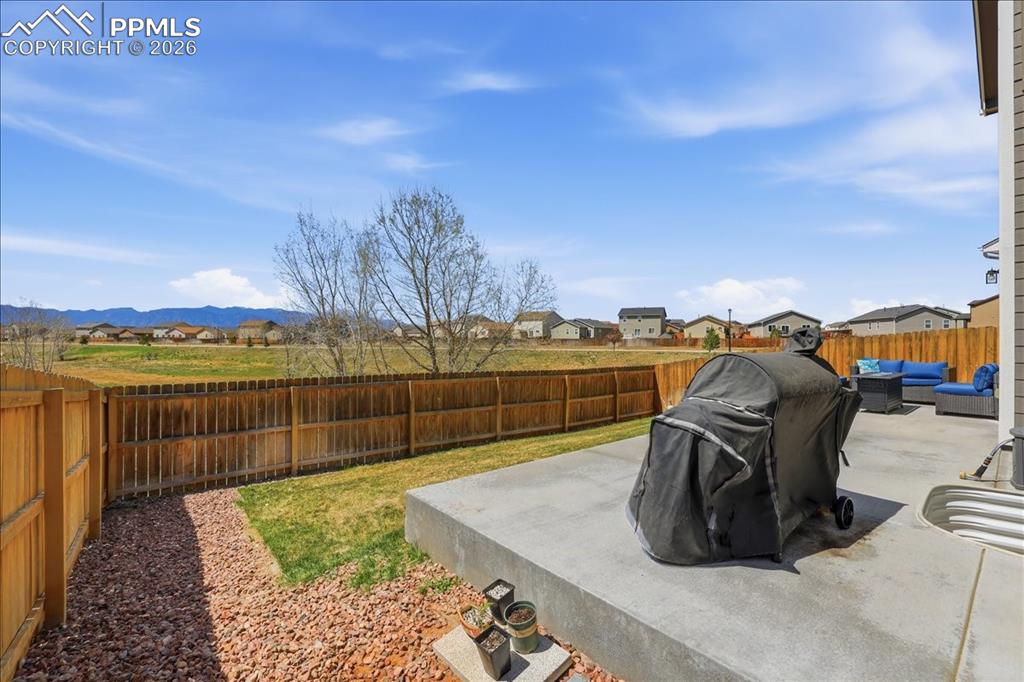 Image 39 of 47: The property features a concrete patio and a fenced yard with a grassy area