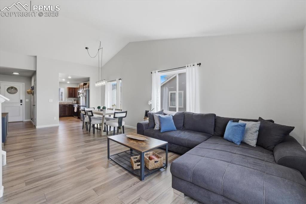 Image 4 of 47: The living space features vaulted ceilings, light-colored walls, and wood-l