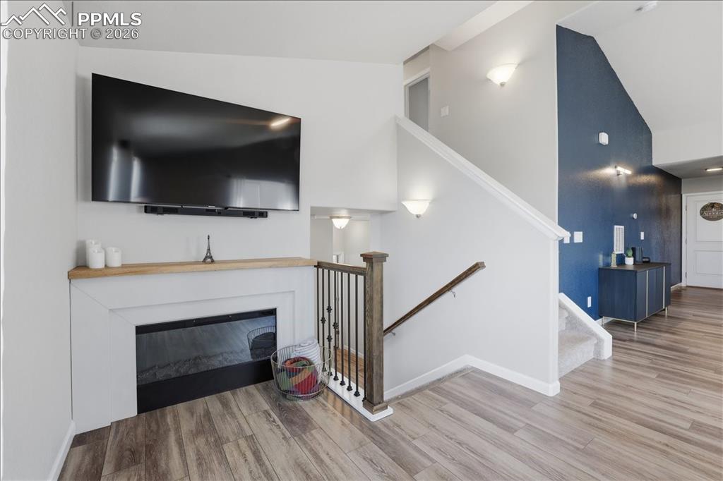 Image 5 of 47: Living area featuring wood-look flooring, a fireplace with a light wood man